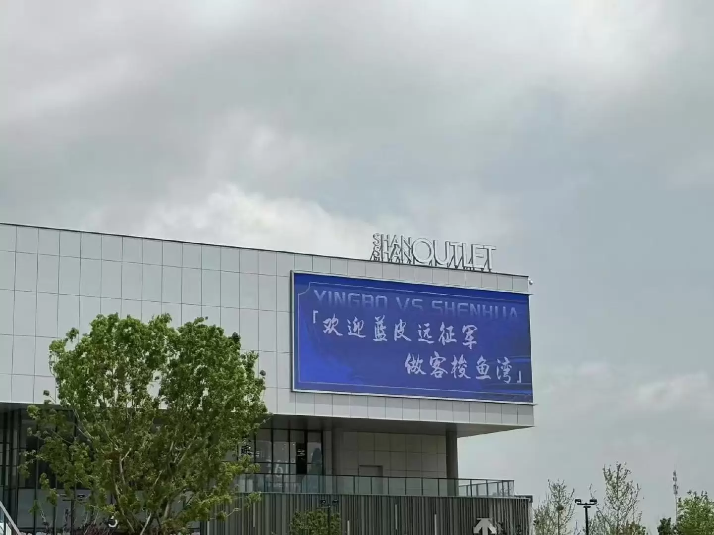 欢迎远征军，英博vs申花赛前梭鱼湾球场外展示巨幅海报
